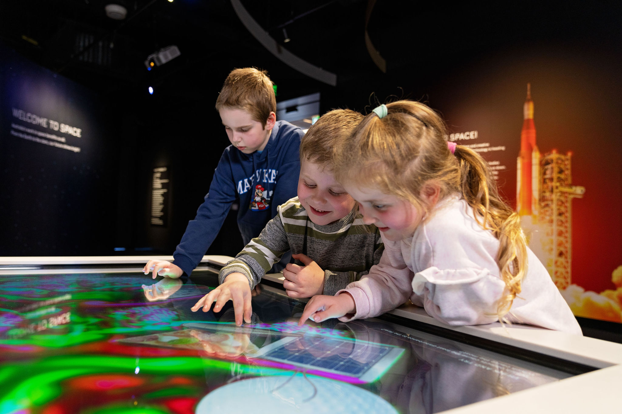 Young children playing with a space exhibit