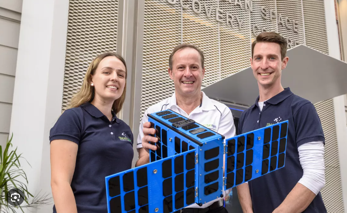 People posing with a spacecraft