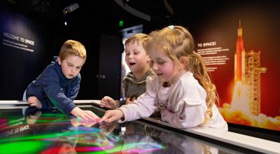 Young children playing with a space exhibit
