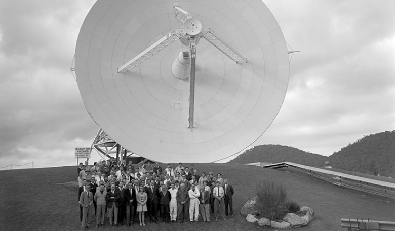 Black and white photo of the Honeysuckle Creek team in front of the telescope.