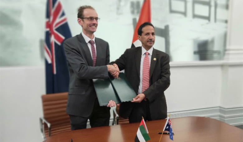 Photo of representatives of the Australian and UAE Space Agencies shaking hands in a boardroom after signing an MoU