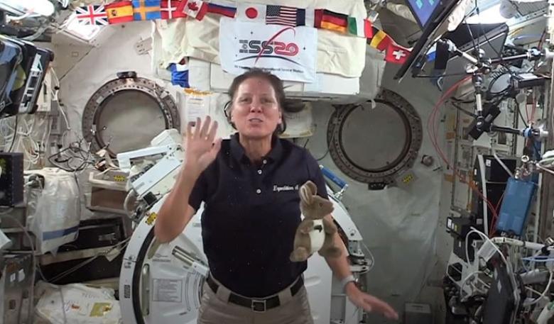 An astronaut aboard a space shuttle, with a toy kangaroo floating in front