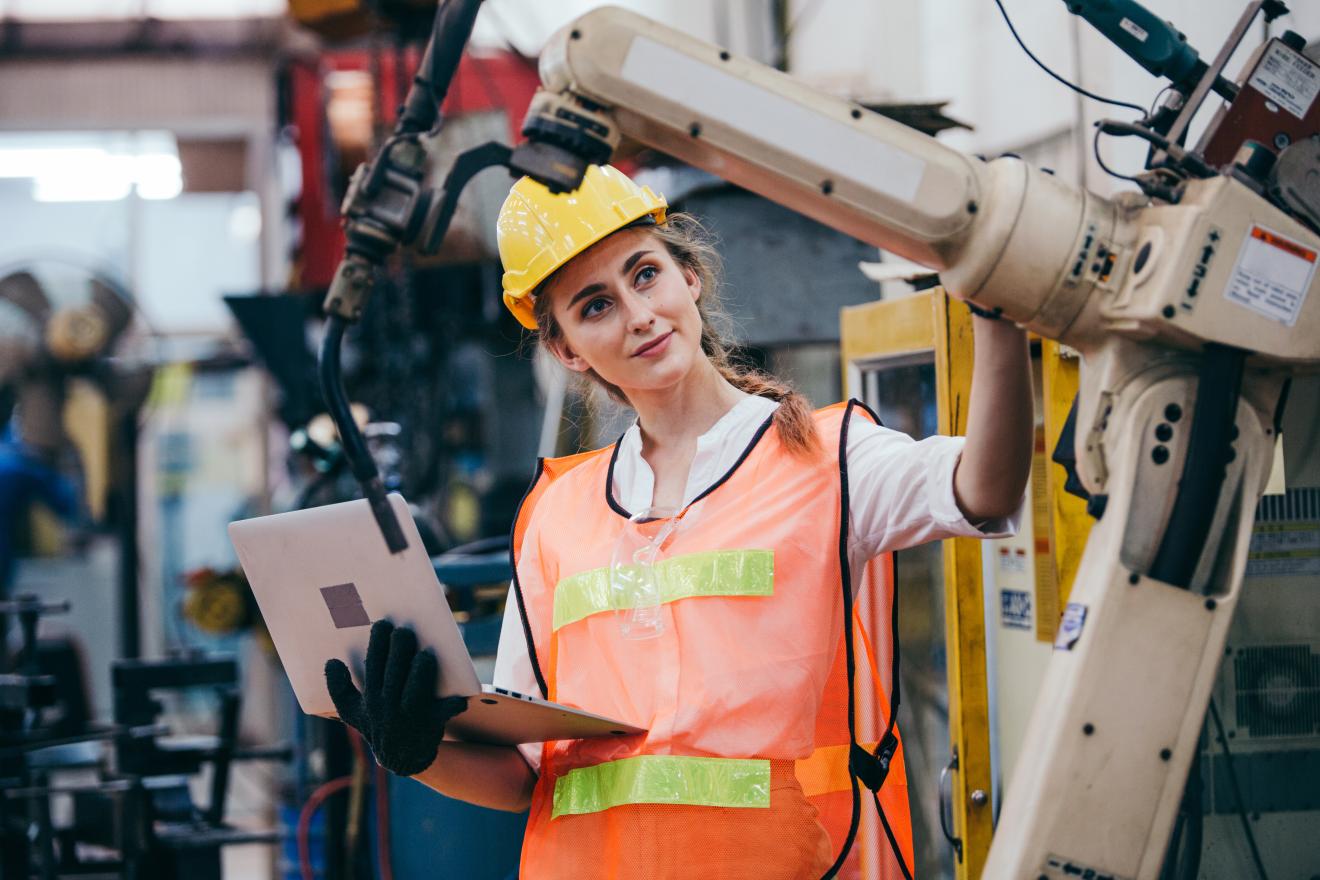 Robotics engineer inspects robotic manufacturing arm