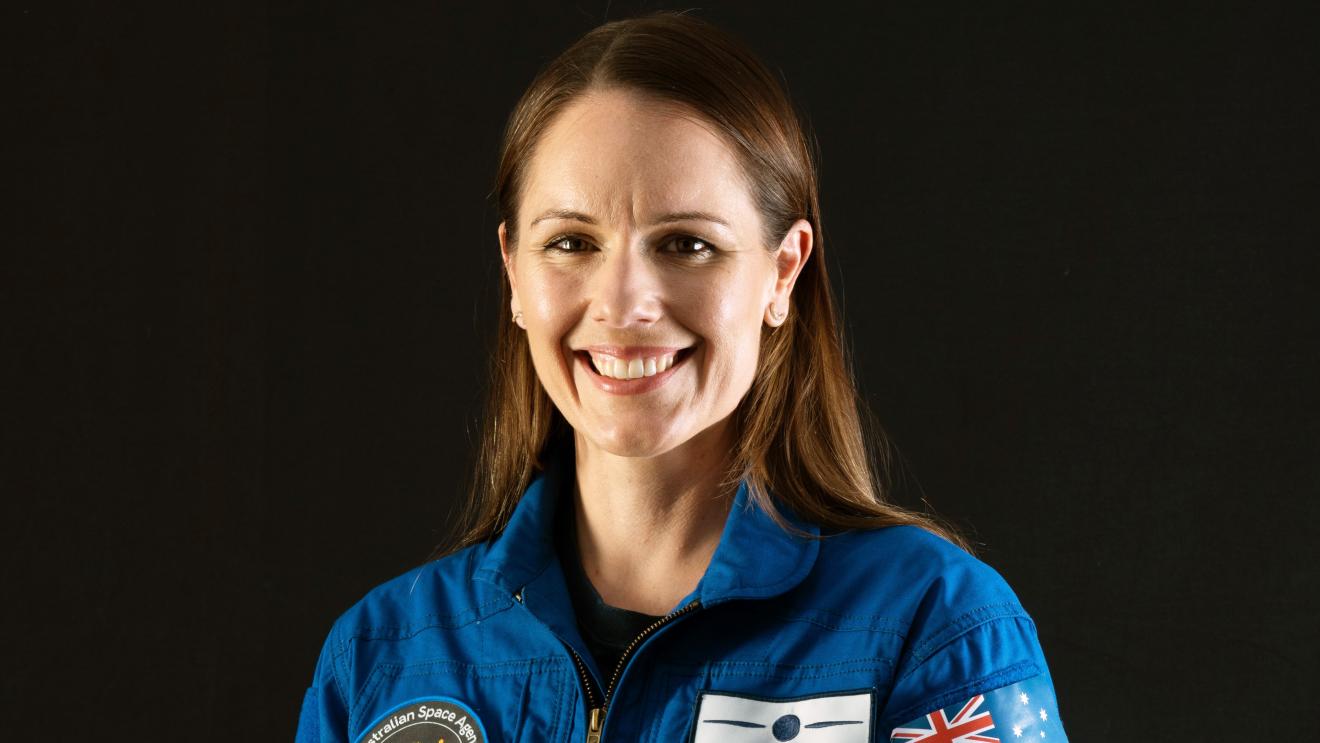 woman in an astronaut unifrom smiling.