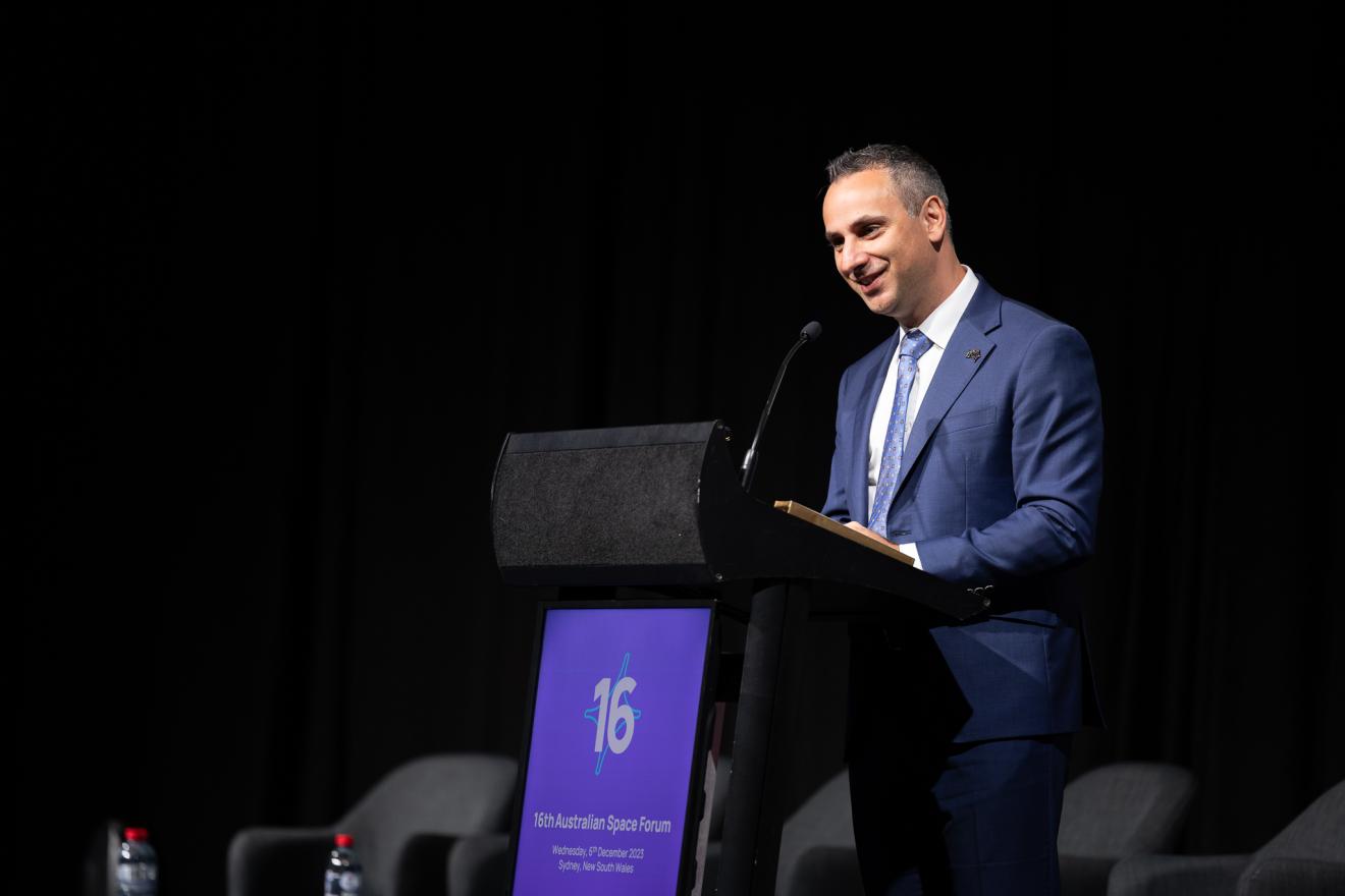 A person in formal attire speaking at an event