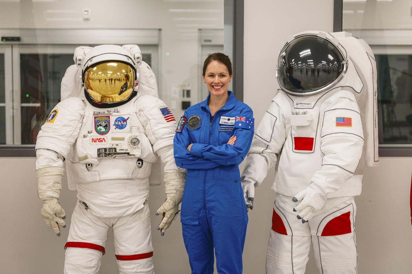 woman in an astronaut unifrom smiling.