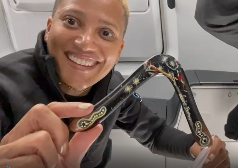 An astronaut showcasing a boomerang inside a rocket in space.