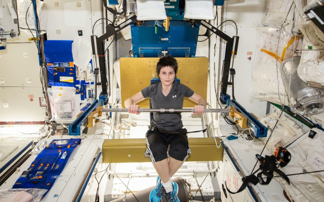 person in microgravity exercising