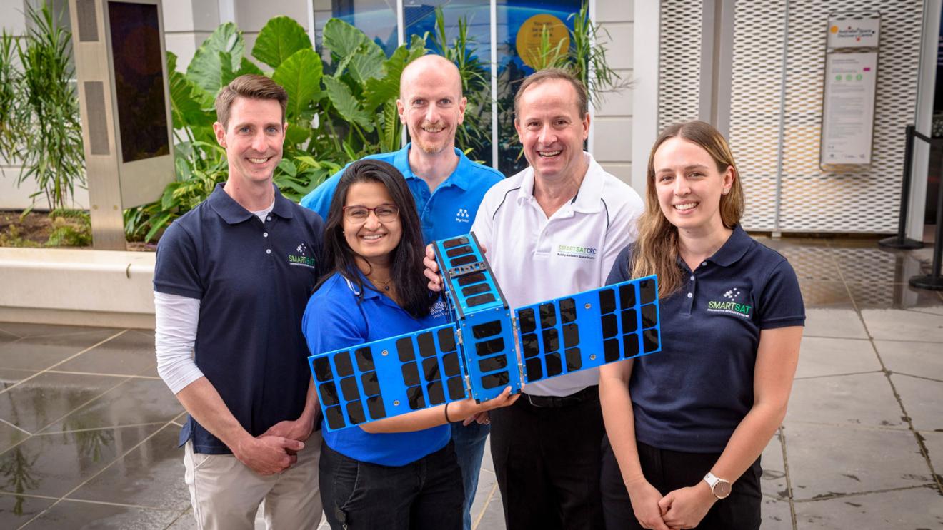 People posing with a spacecraft