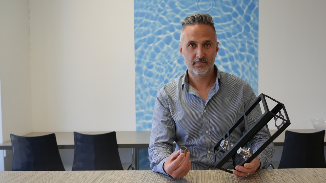 Scott Edwards from entX holding components of the company's radioisotope heater unit.