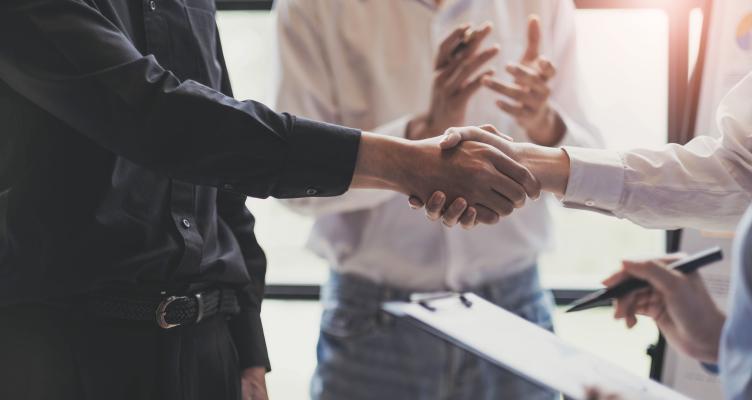 Two people shake hands.