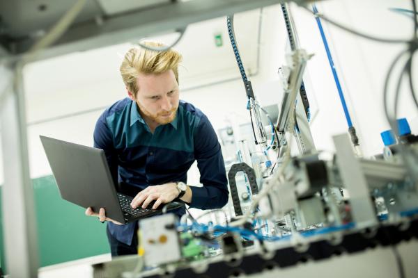 Electrical engineer  examines automated machine