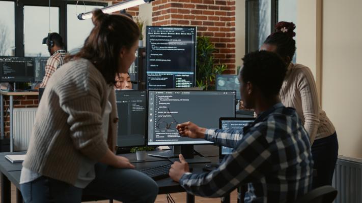 Machine learning engineers huddle around desktop computer