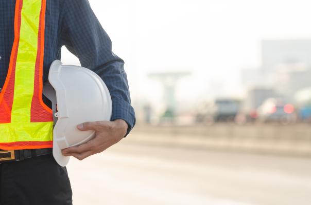 Person in high visibility clothing holding hardhat