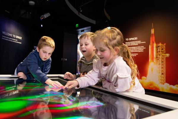 Young children playing with a space exhibit