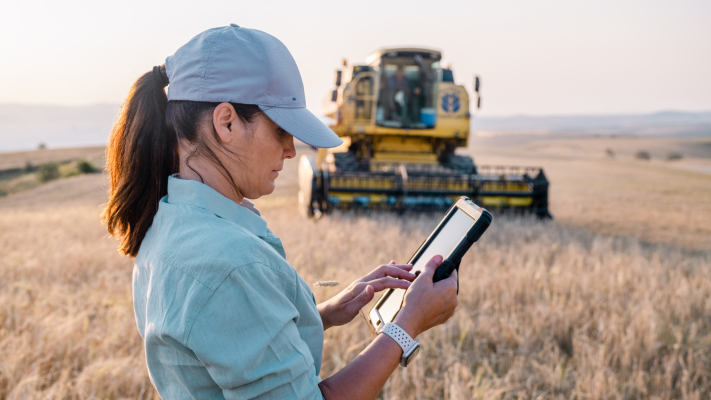 A farmer working on a tablet on a farm.