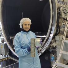 Zahra Esmati holds a spaceship component infront of a large spaceship section