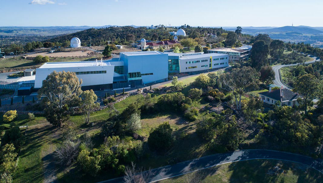 Aerial view of Mount Stromlo Observatory with the National Space Test Facility in the foreground.