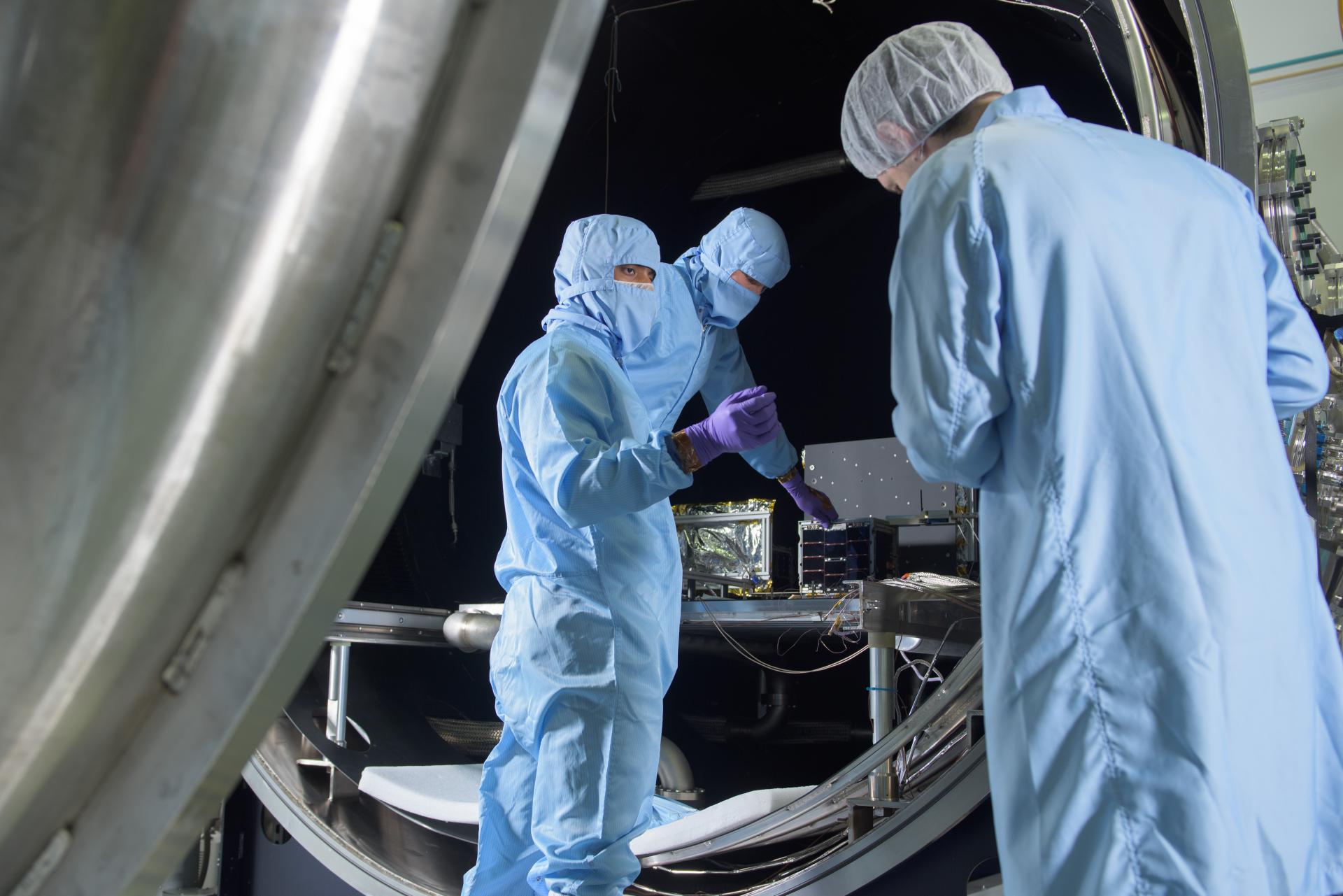 A group of people wearing blue hazmat suits