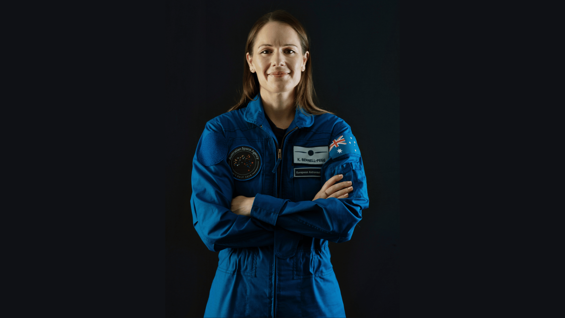 woman in an astronaut unifrom smiling.